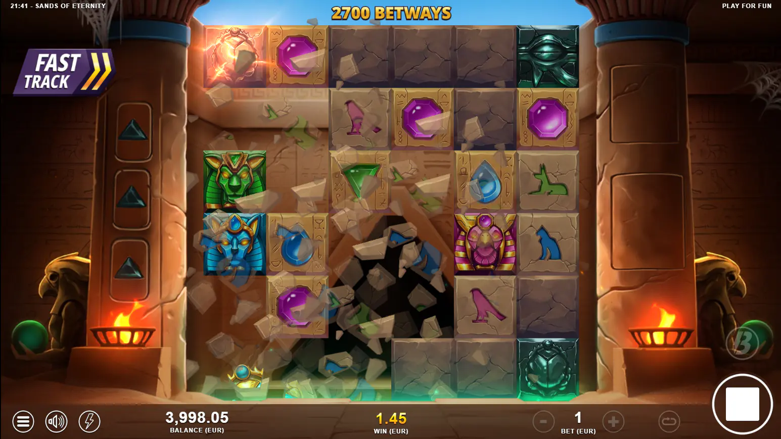 An avalanche sequence in Sands of Eternity, with winning symbols exploding to remove blockers and expand the grid, showcasing the core gameplay mechanic.