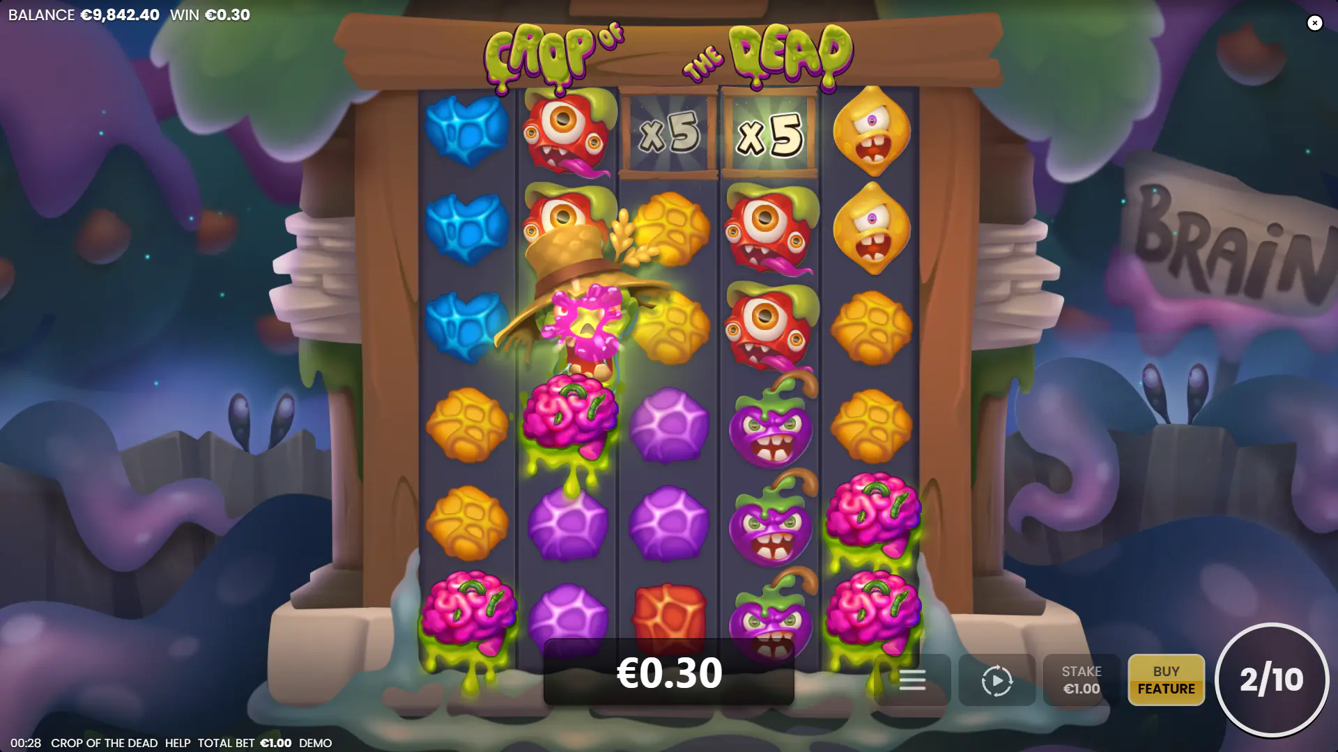 A zombie character above the reels dropping x5 multipliers onto the grid after eating Brain symbols.